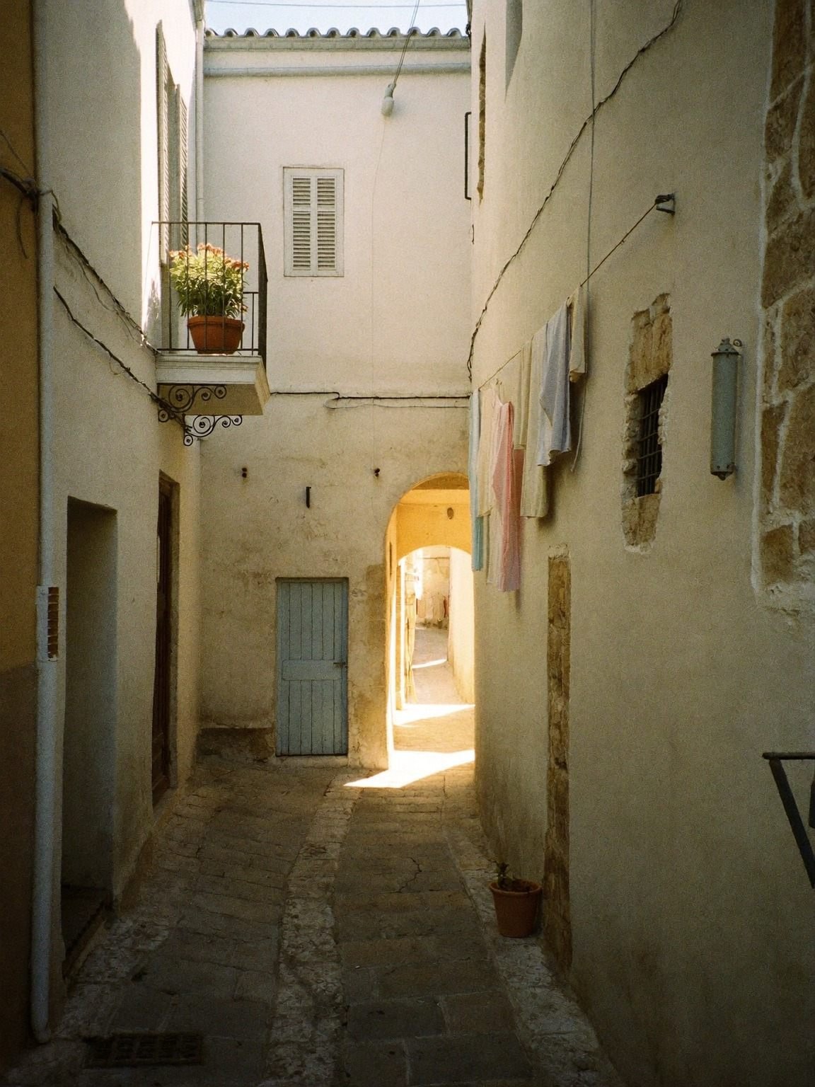 Sonnenbeschienene Gasse in der Altstadt von Conversano, Apulien