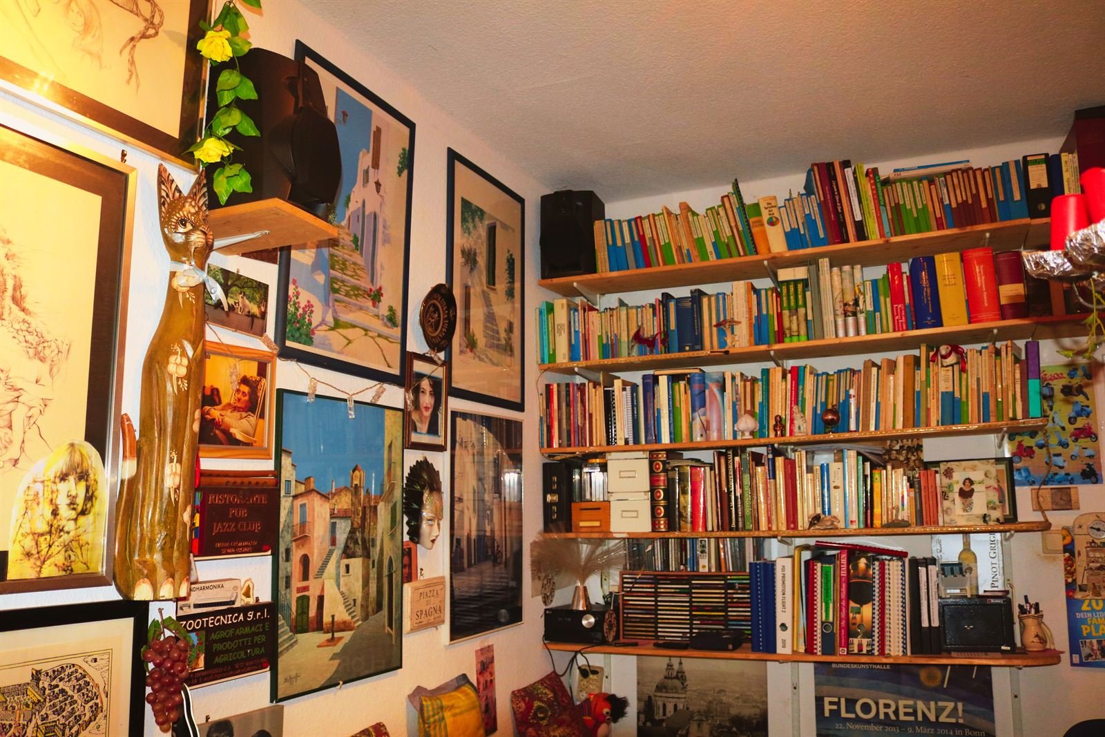 Wand mit Bildern und ein Regal voller Kochbücher