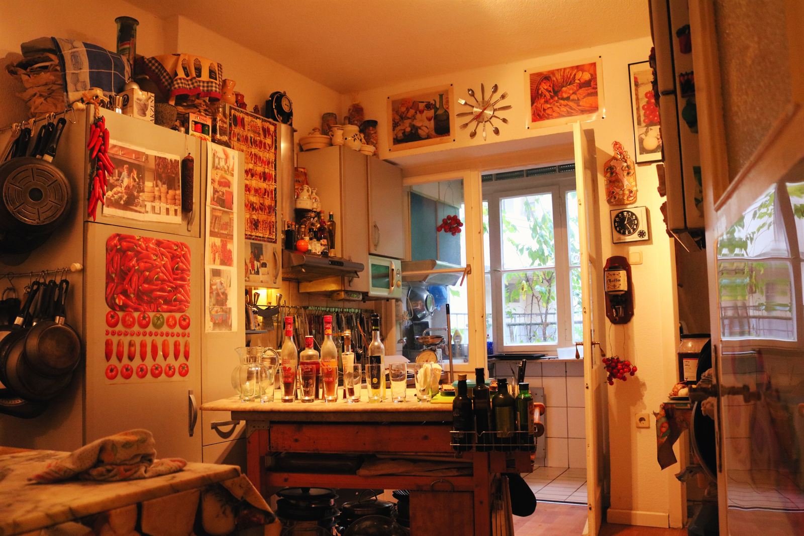 Blick in die Küche des Kochstudios mit Töpfen, Flaschen und Fenster