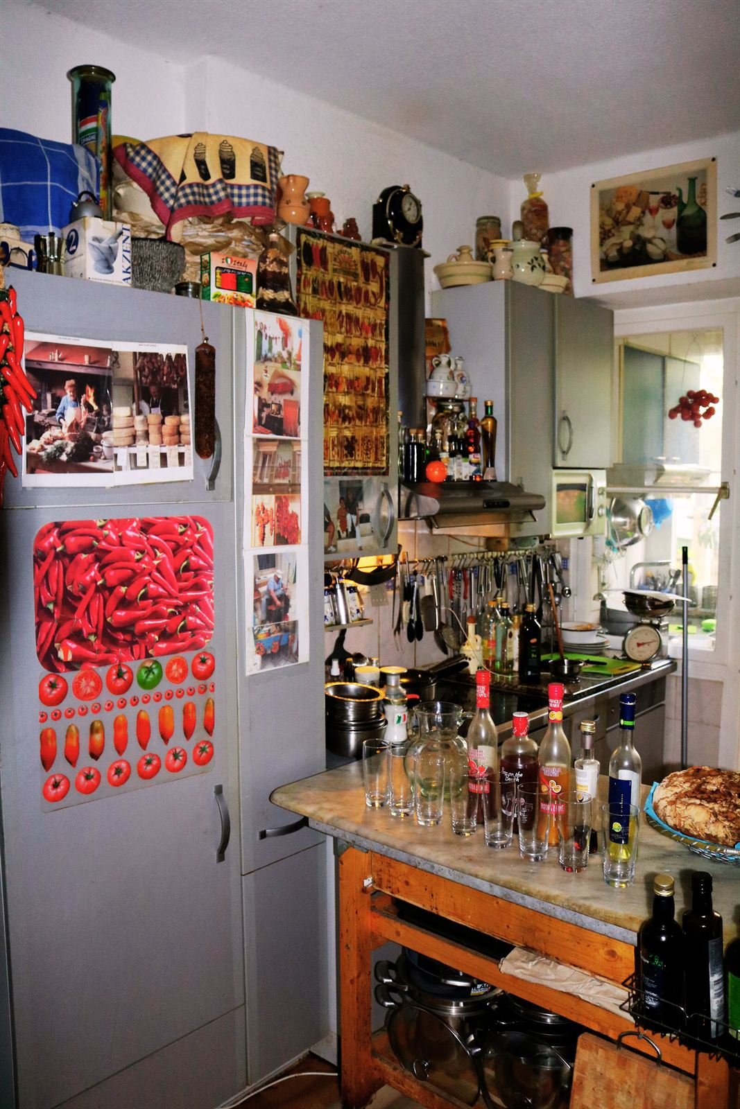 Küchenzeile mit Kühlschrank voller Magnete und Flaschen auf der Arbeitsfläche